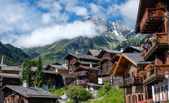 Traditional wooden Swiss chalet surrounded by mountains
